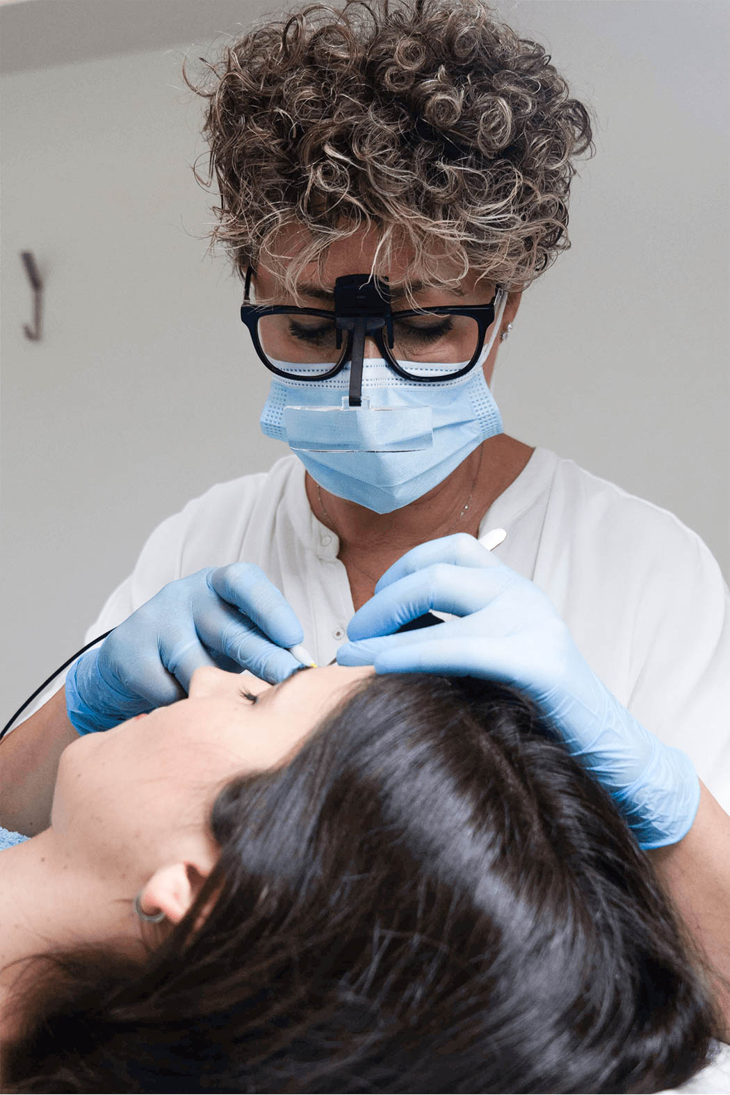 Especialista realizando tratamiento de eléctrica en cejas de paciente